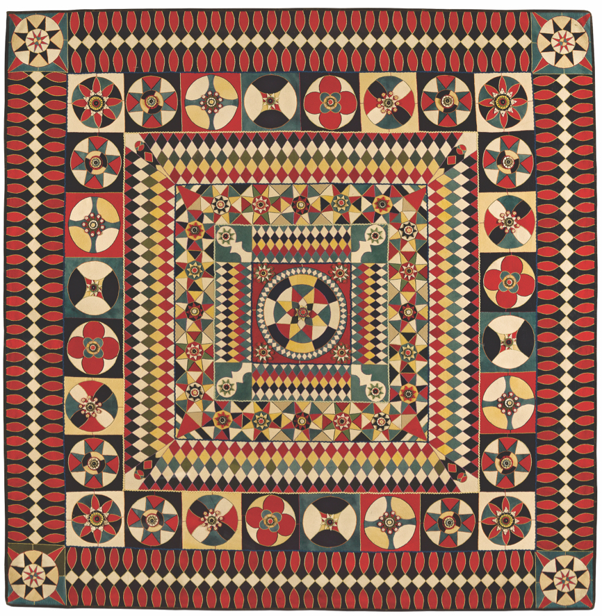 Quilt with geometric patterns in red, yellow, green, black and white