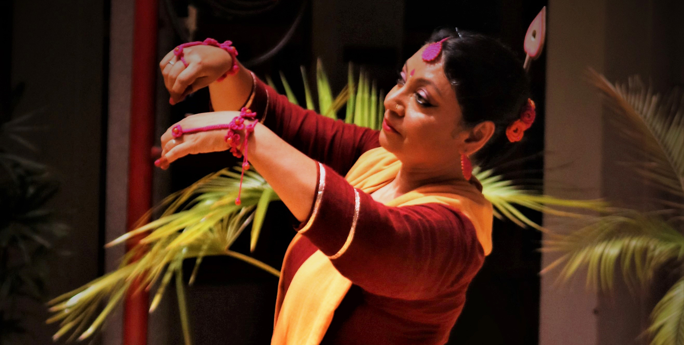 An Indian woman dances with both arms outstretched