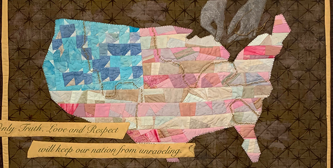 A quilt depicting a map of the United States in the patterns and colors of the American flag.