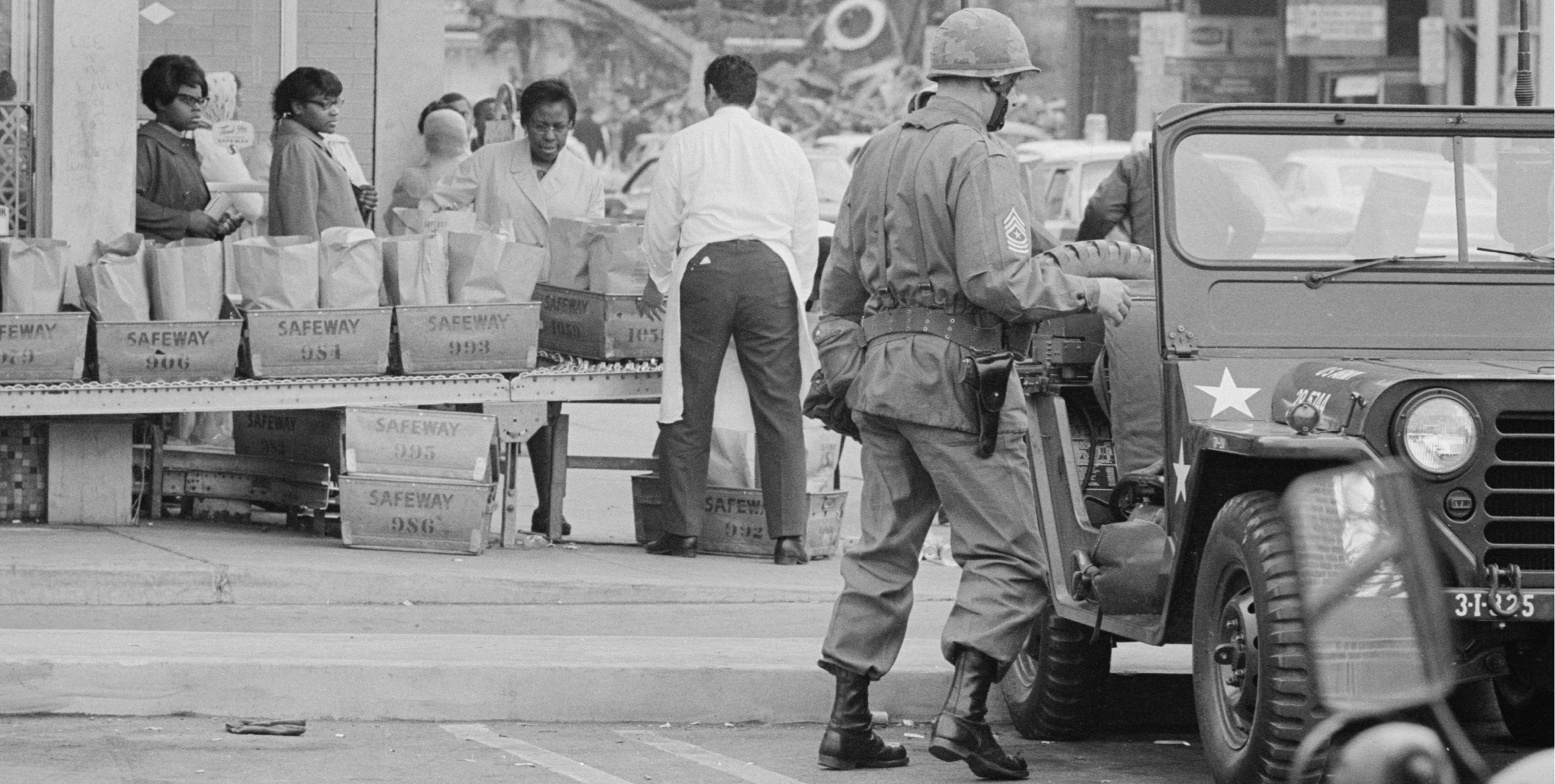 Black-and-white photograph of a street scene with soldiers