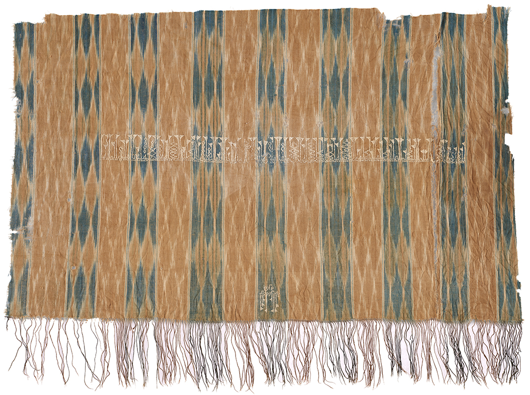 Large ikat fragment owith two lines of Arabic inscription in a Yamanite kufi style. Textile shows stripes and ikat patterning in lozenges and chevrons.