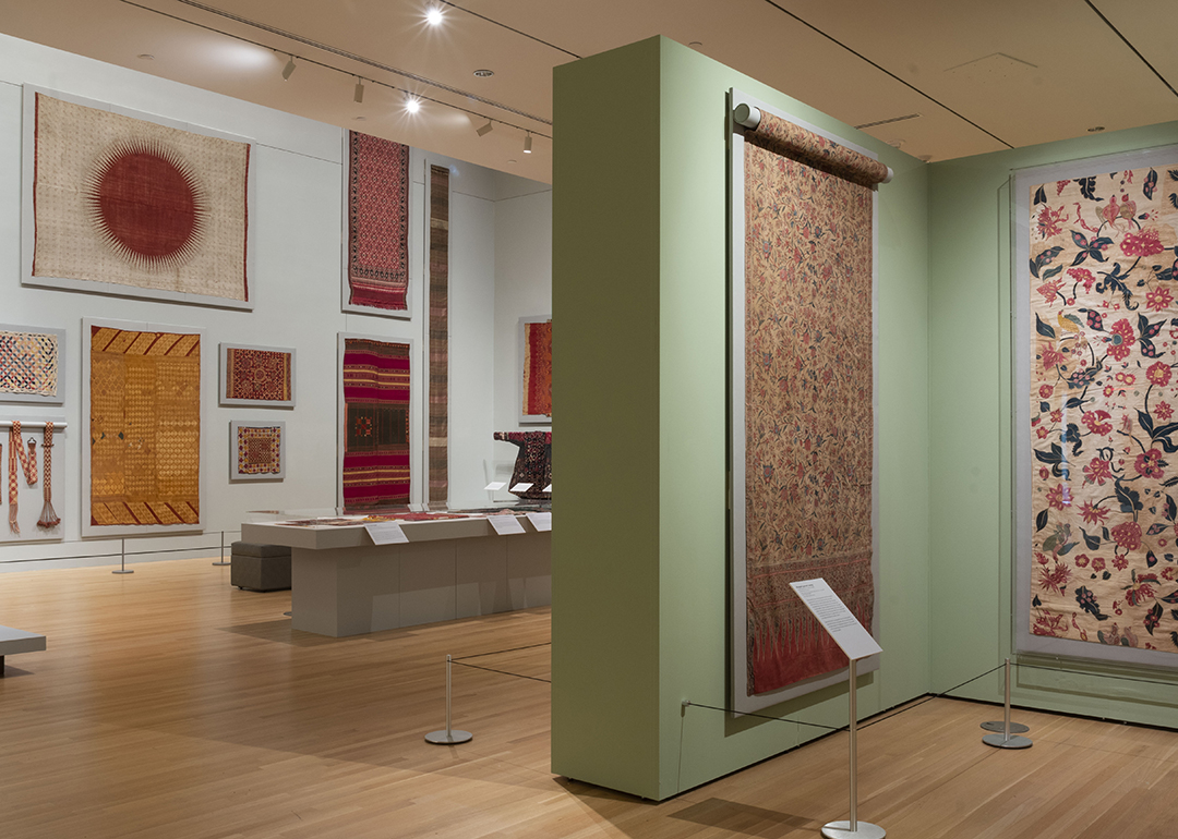 A museum gallery with colorful Indian textiles on display