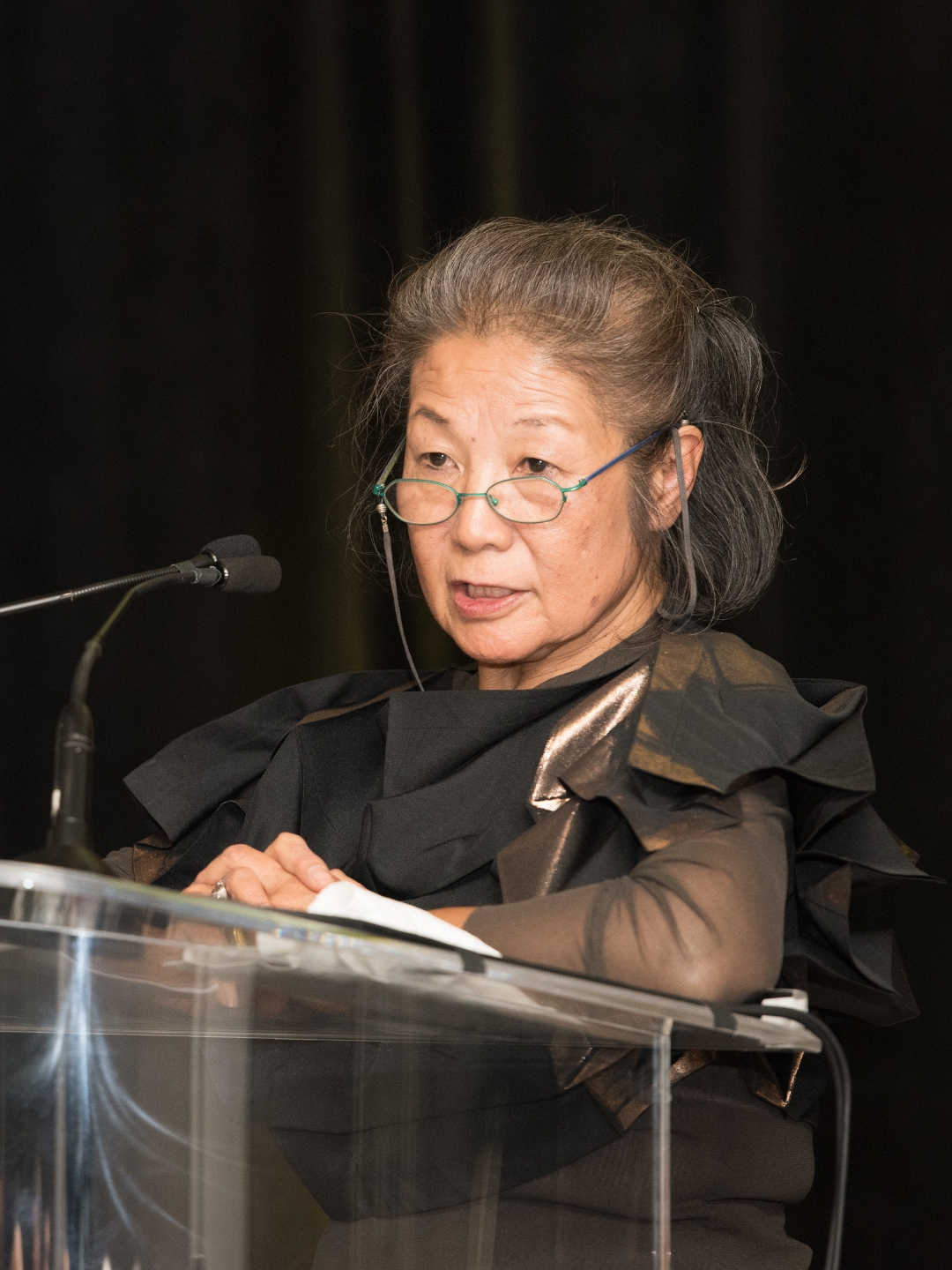 Yoshiko Iwamoto Wada presents from a podium during a formal event