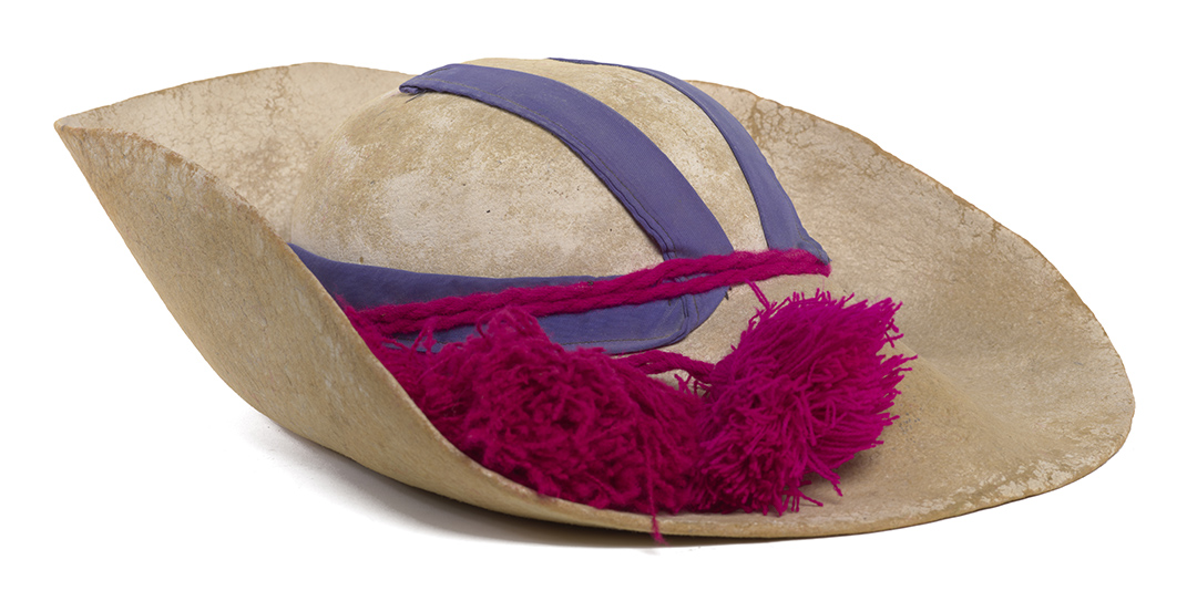 Wide-rimmed hat with magenta pompoms at the back