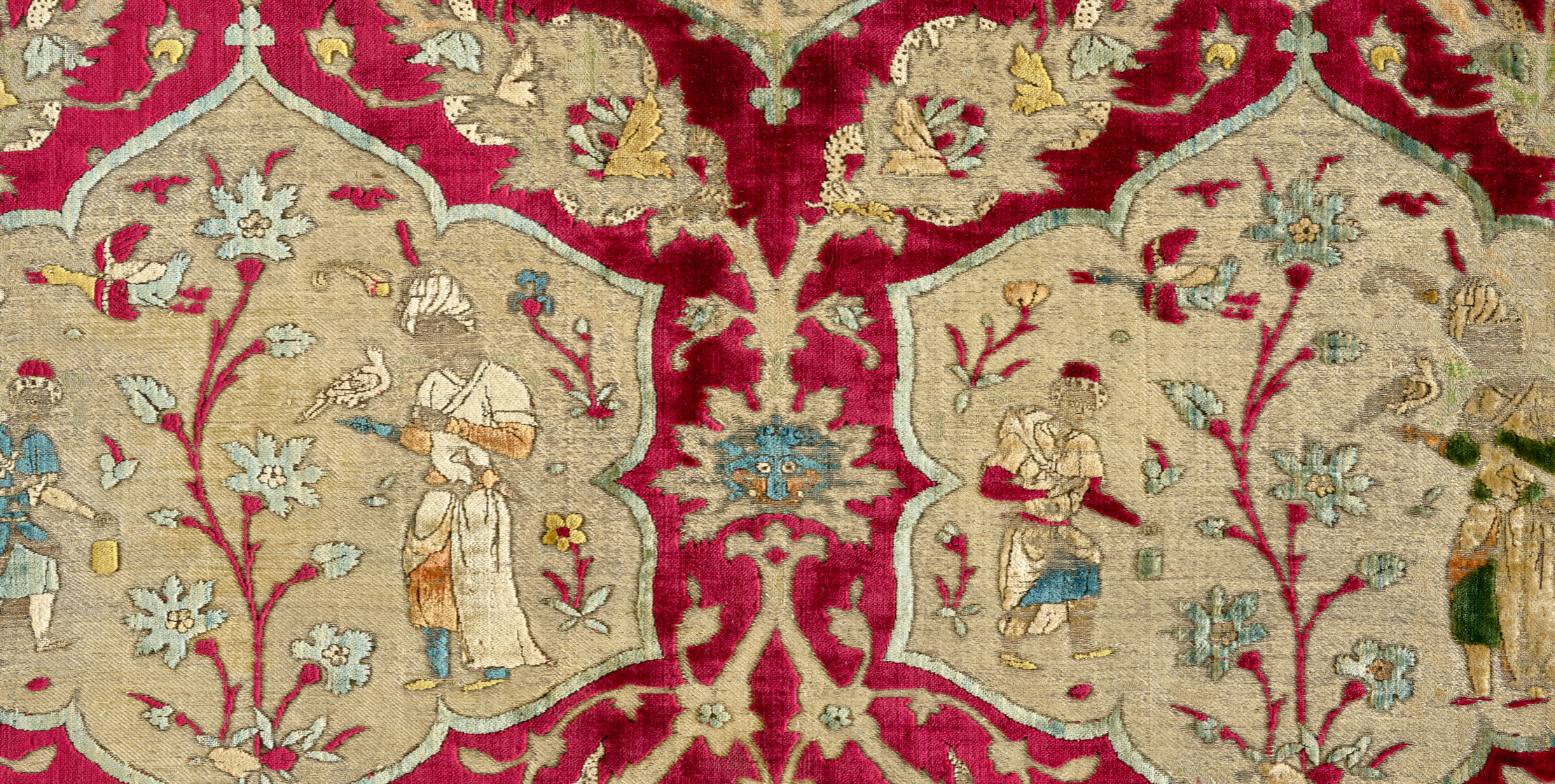 Velvet fragment with lobed medallions bearing a Safavid falconer with attendant. The sporting bird is perched on her master's glove.