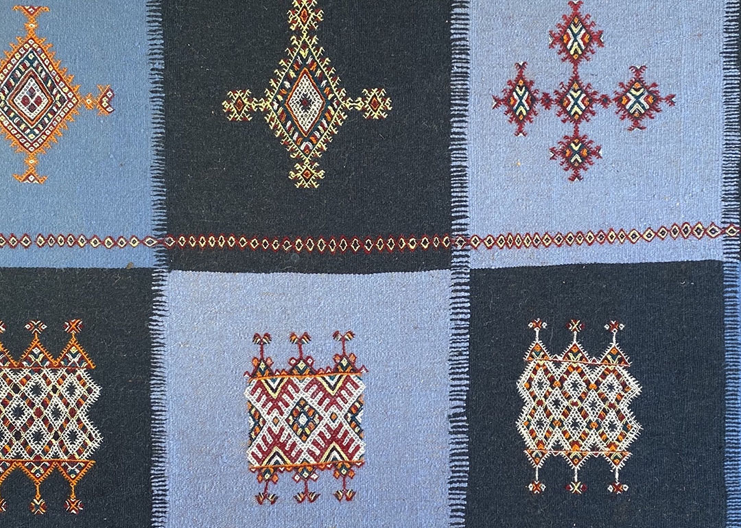 blue checkerboard textile with geometric embroidery