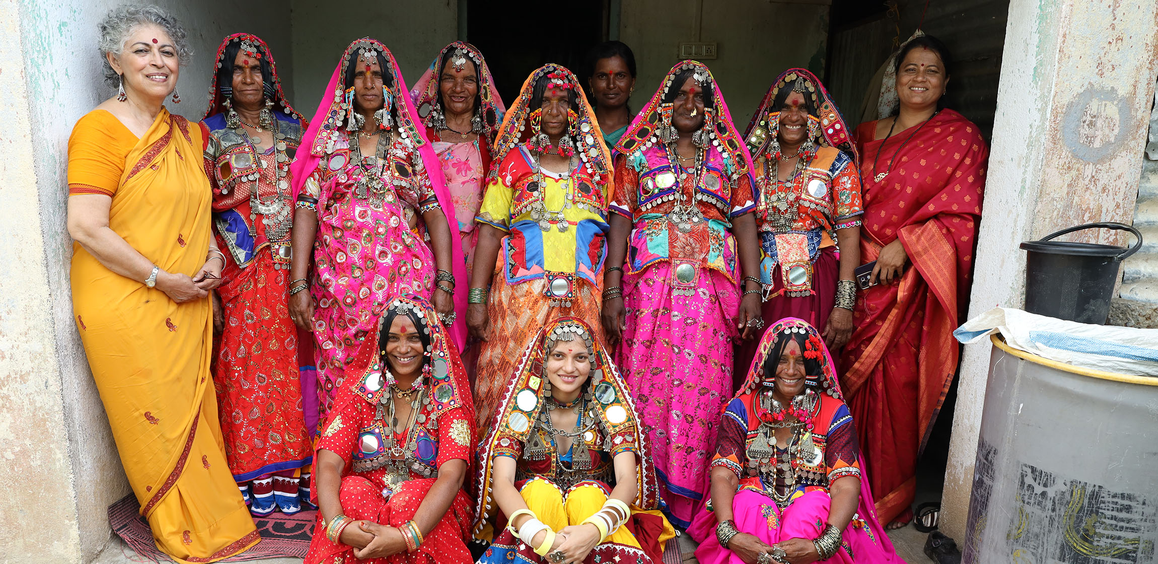 a group photo of women wearing colorful sari's and headscarves 