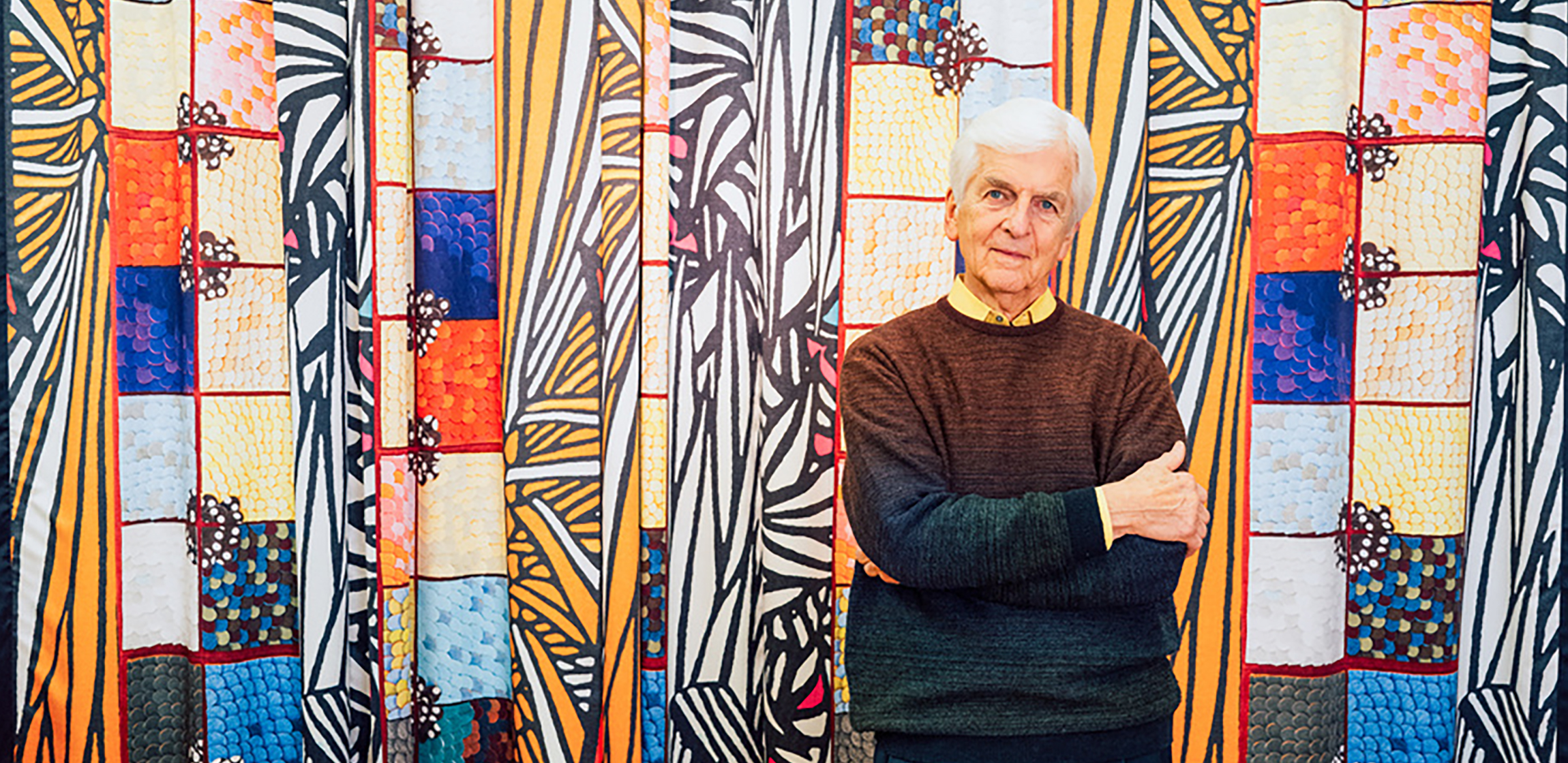 man standing in front of a colorful banner