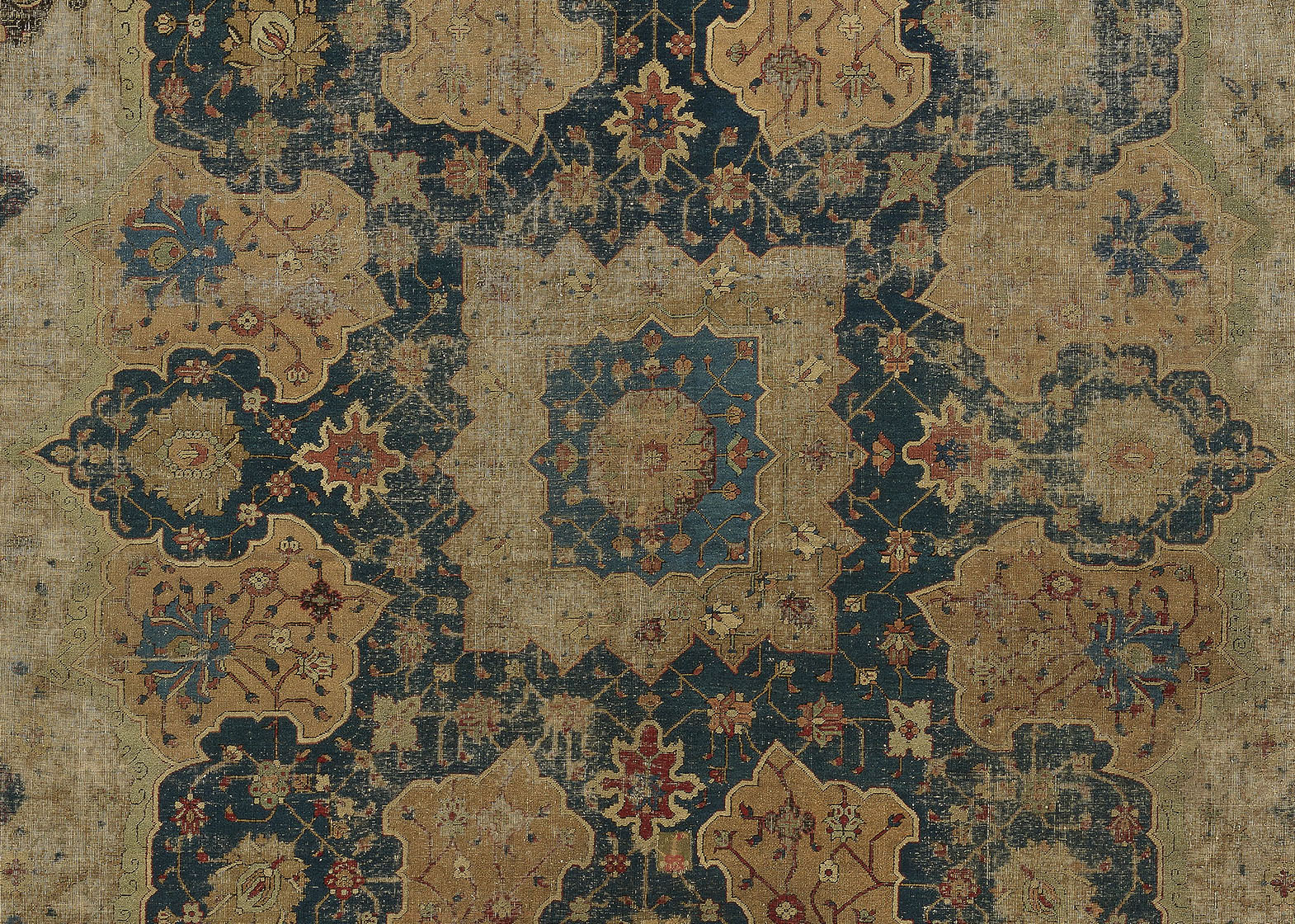 detail of a large faded rug with central medallion