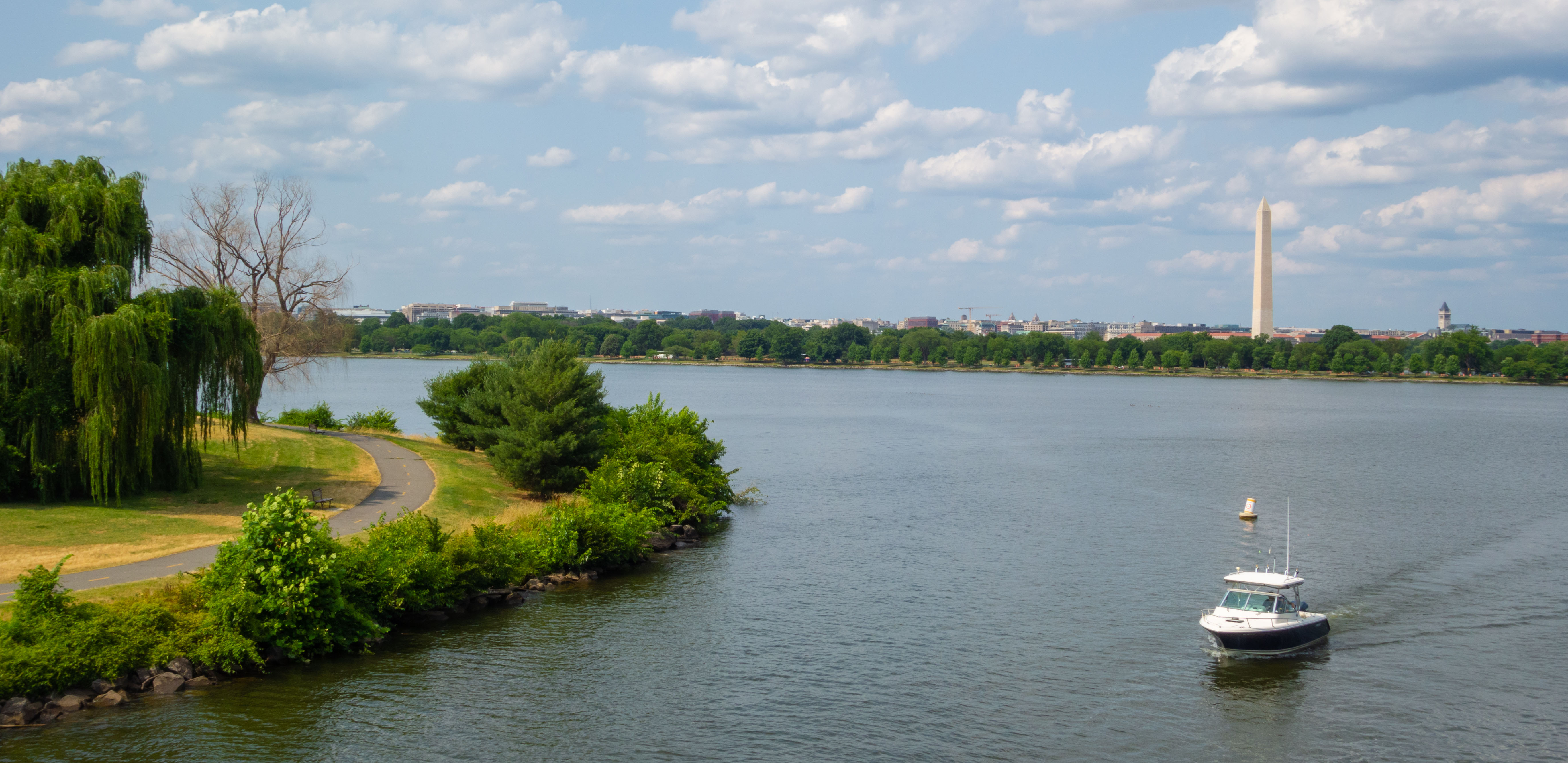 a oat cruising down the anacostia river with the washington monument in the background