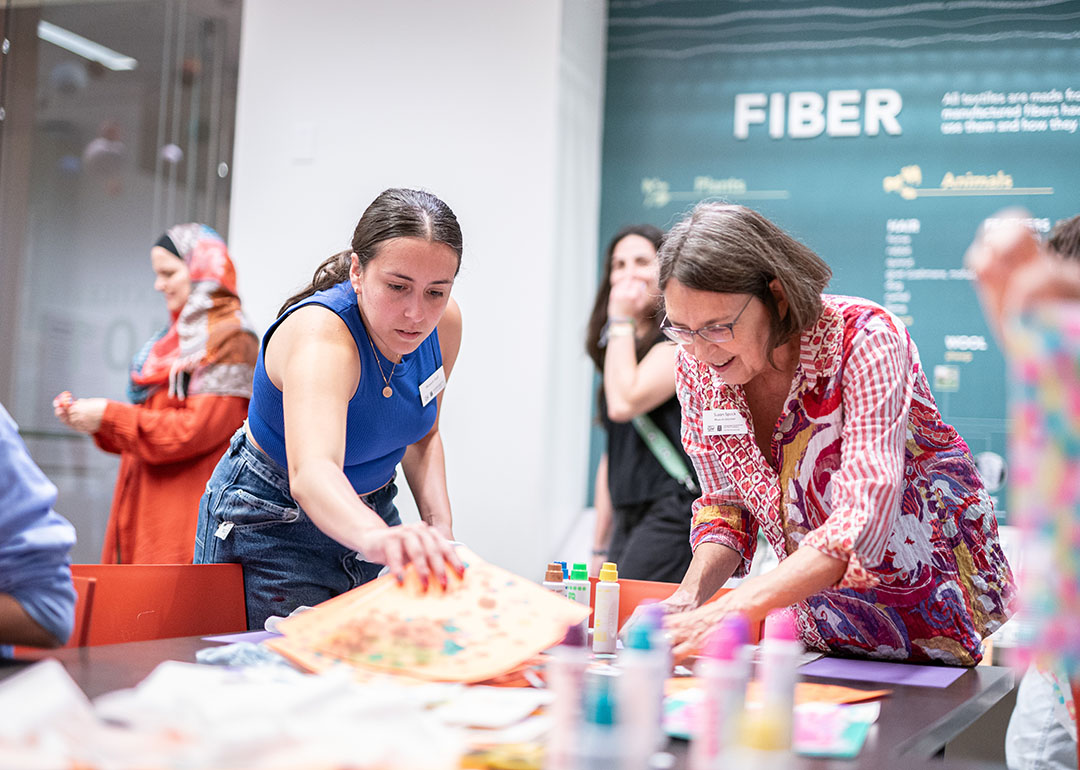 two museum volunteers sort through a table of crafts