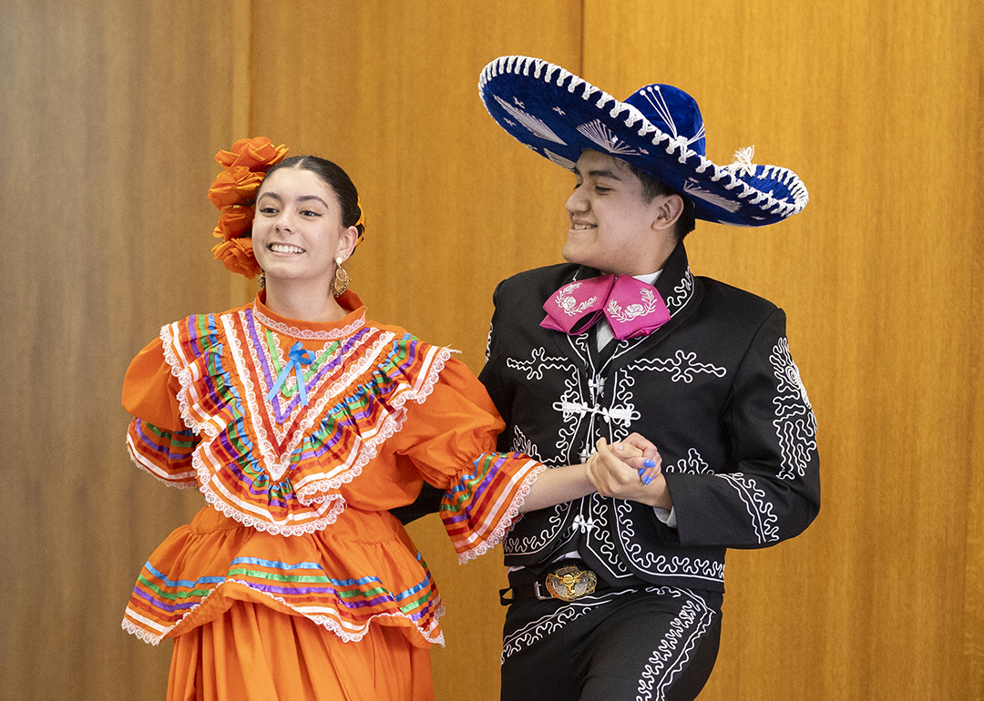 a young man and woman wearing traditional mexican attire dance together