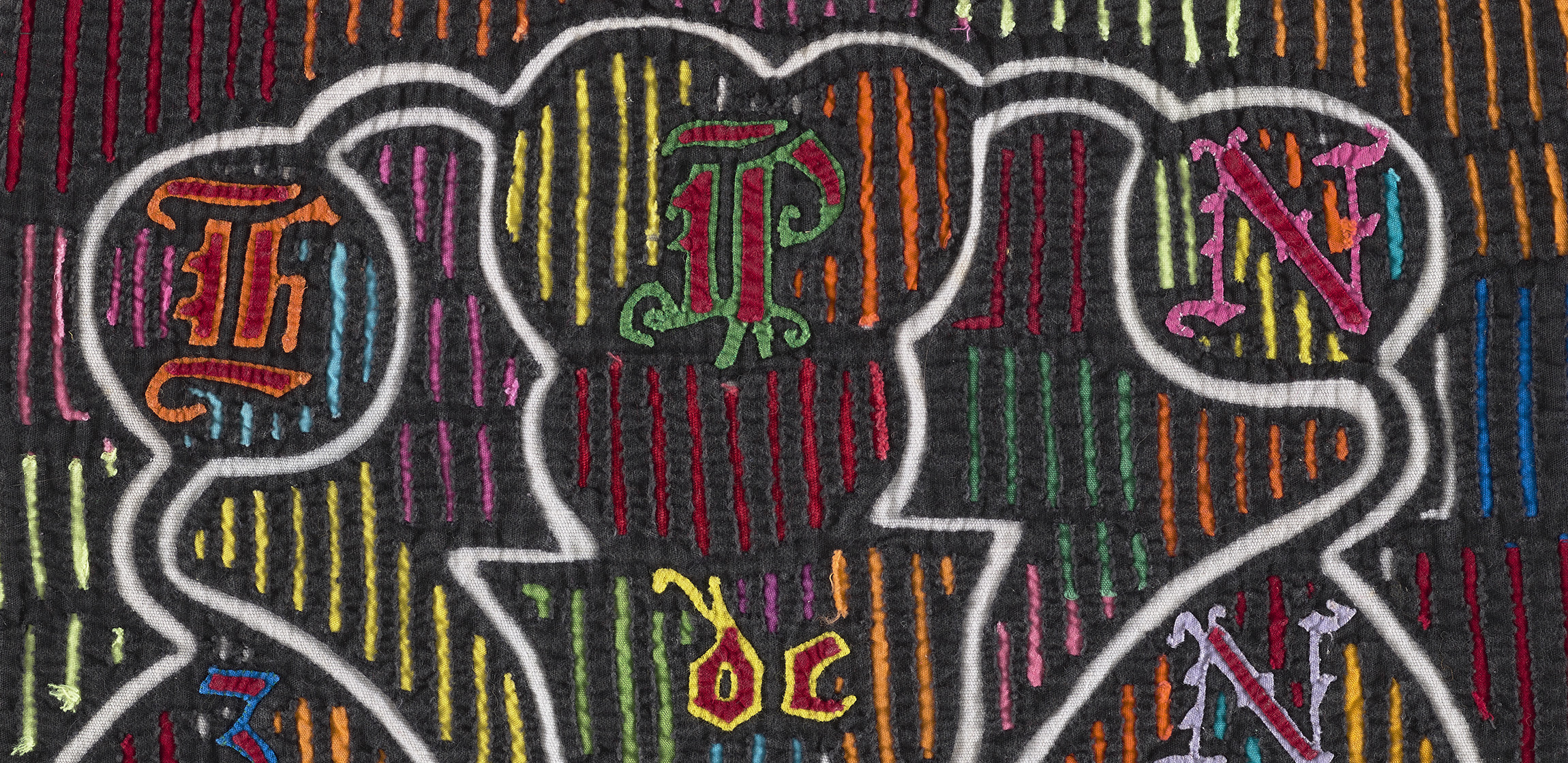 black textile with neon colored embroidered designs 