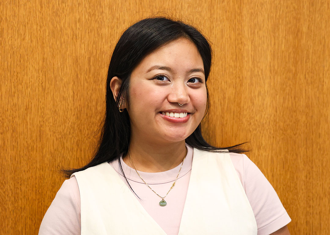 young woman in white sweater vest and pink shirt