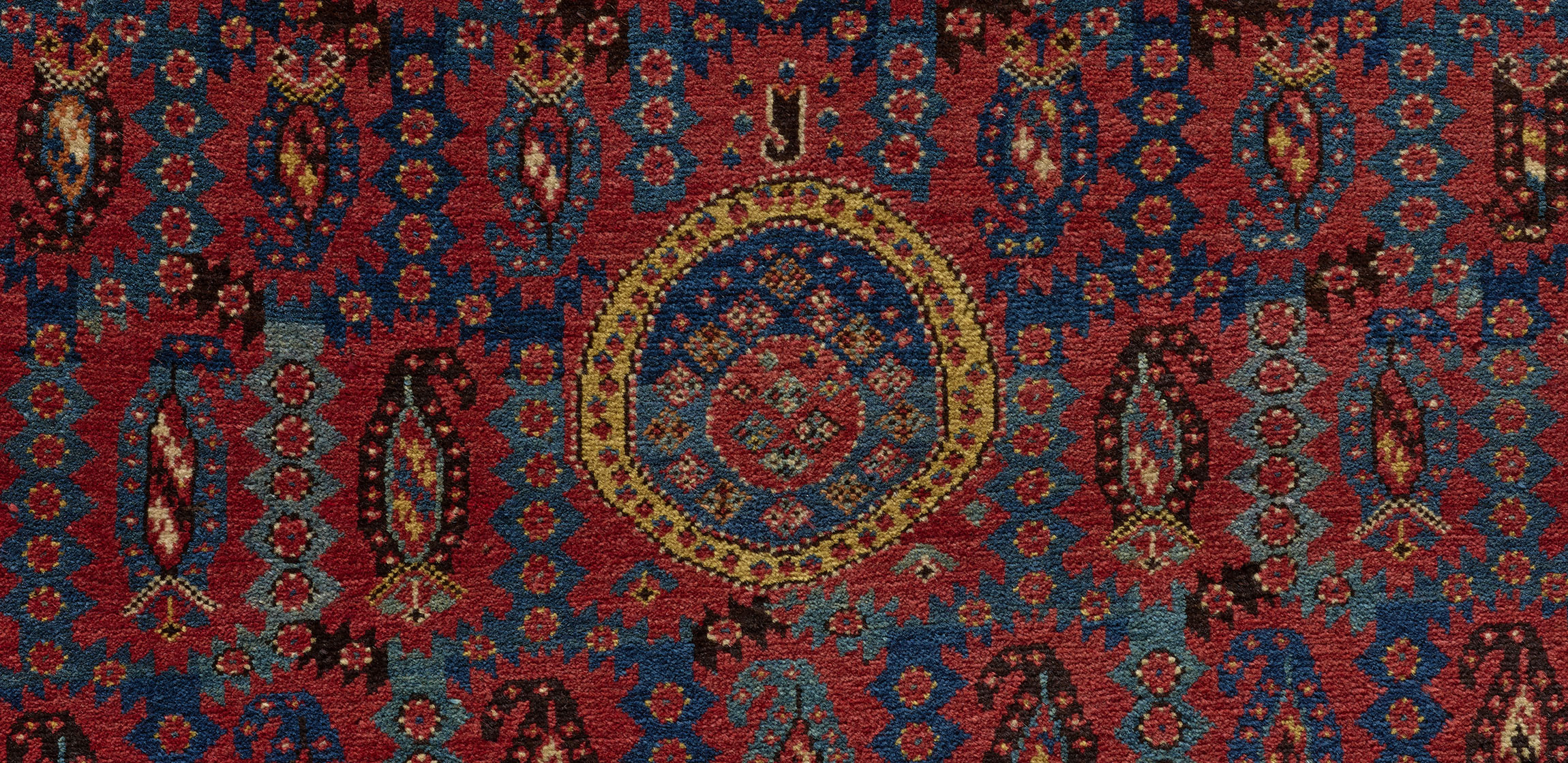 detail of a red carpet with central medallion motif
