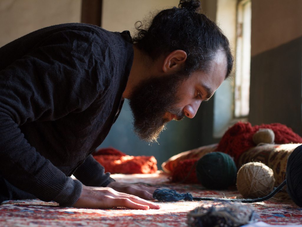 Artist with hands on carpet