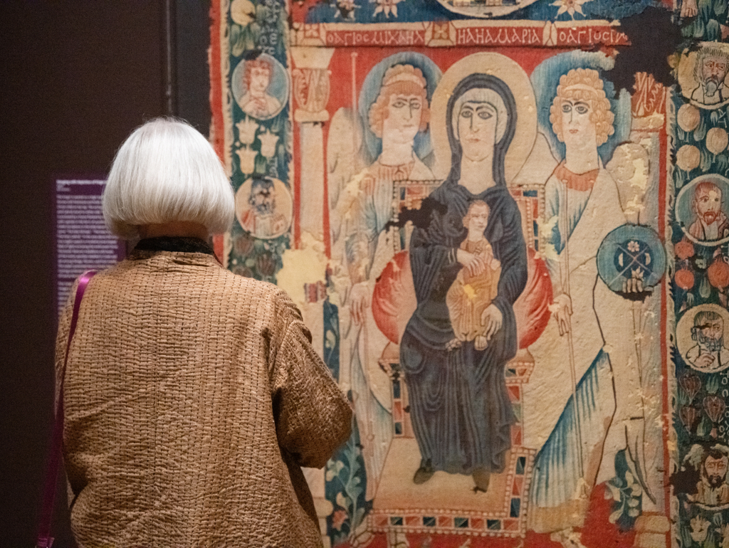 Woman looks at tapestry