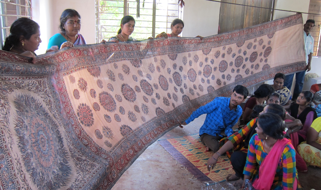 Artists hold up a long shawl