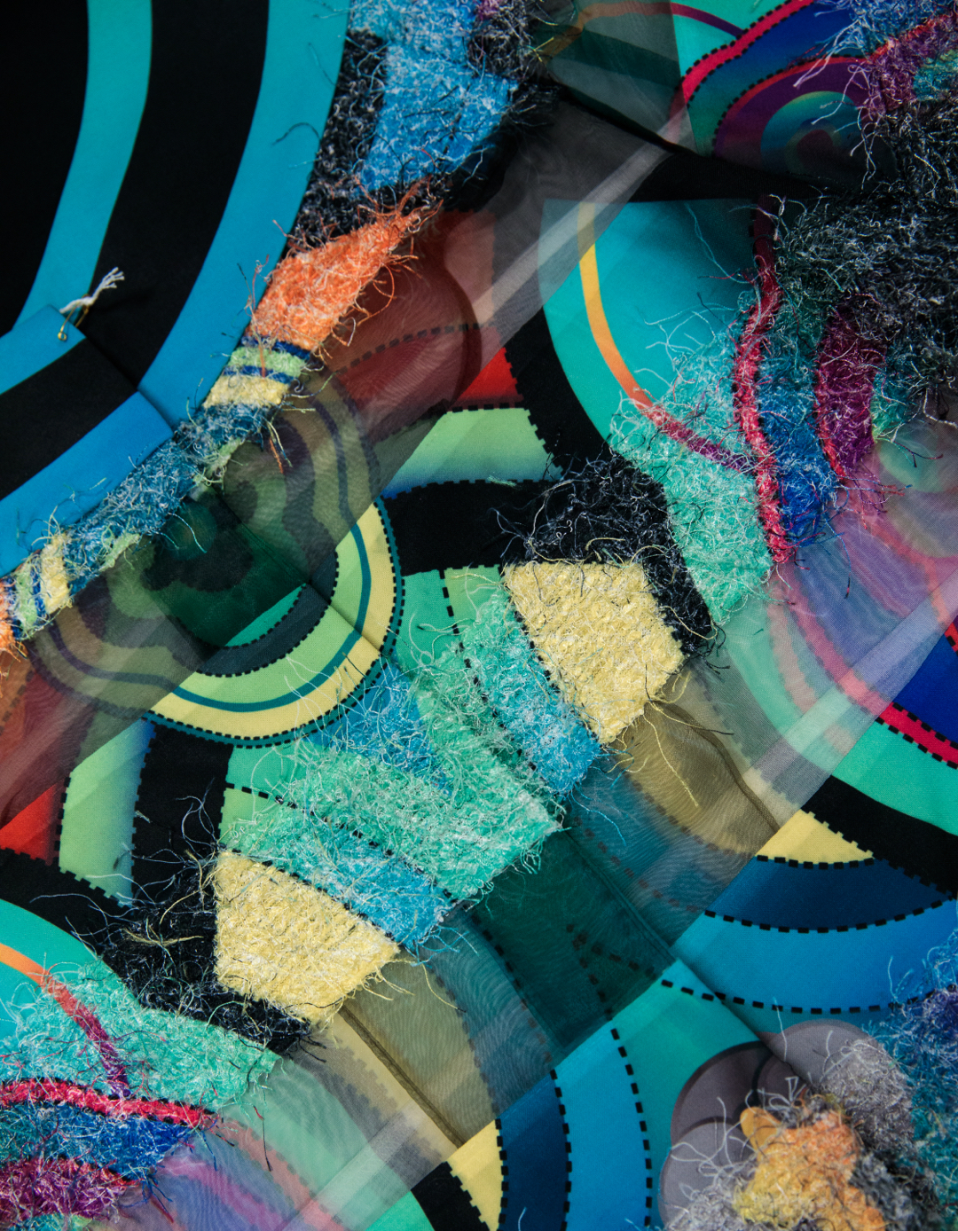 Detail of a dress with a bold, geometric patterns in shades of blue, teal and yellow with thick black borders