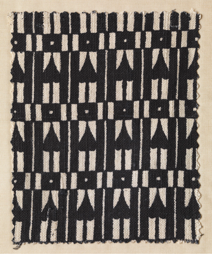 Cream fabric block-printed in black with a design of rows of hearts or spades