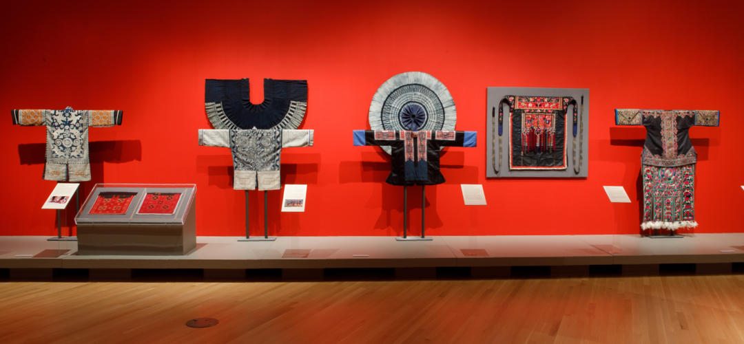 Clothing on display in red gallery