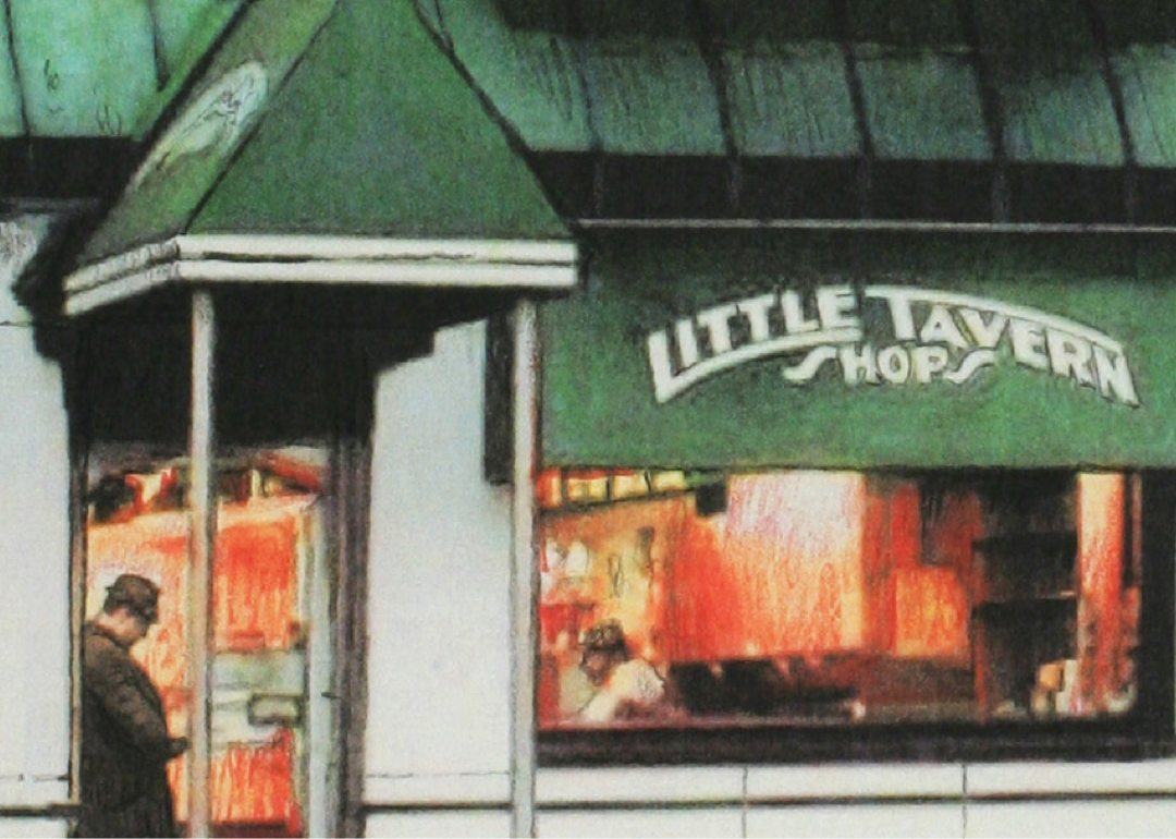 Small white building with green roof and lighted window