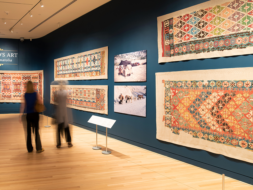 Two visitors walk through an exhibition gallery