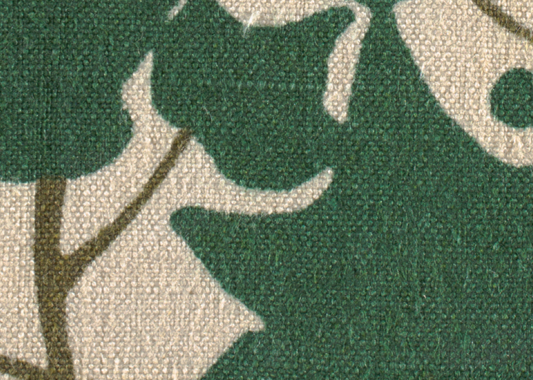 Fabric with design of green ivy leaves and vines on a white ground