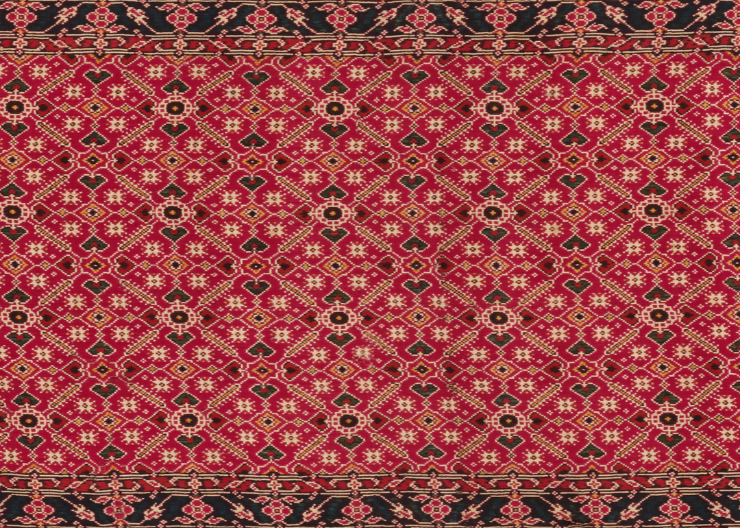 Detail of a textile with red, geometric repeating pattern