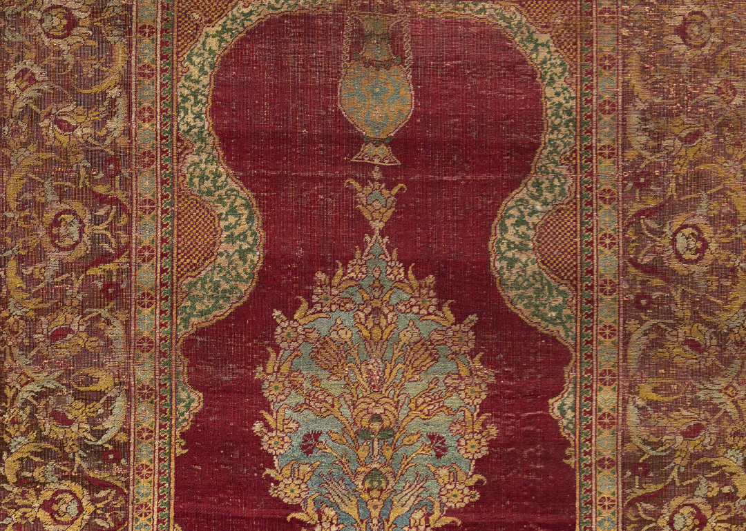 Detail of a textile with an arch at the center and bands of floral motifs on either side and in the center