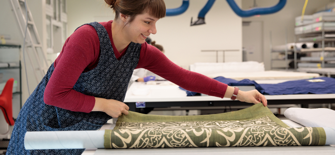 Woman rolling textile on large table