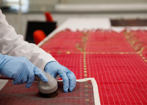 Hands vacuuming textile