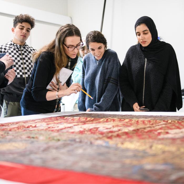 Four people looking at a textile