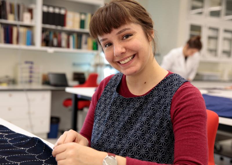women smiling while sewing textile