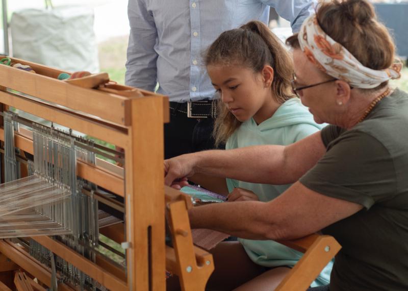 Child weaving on loom