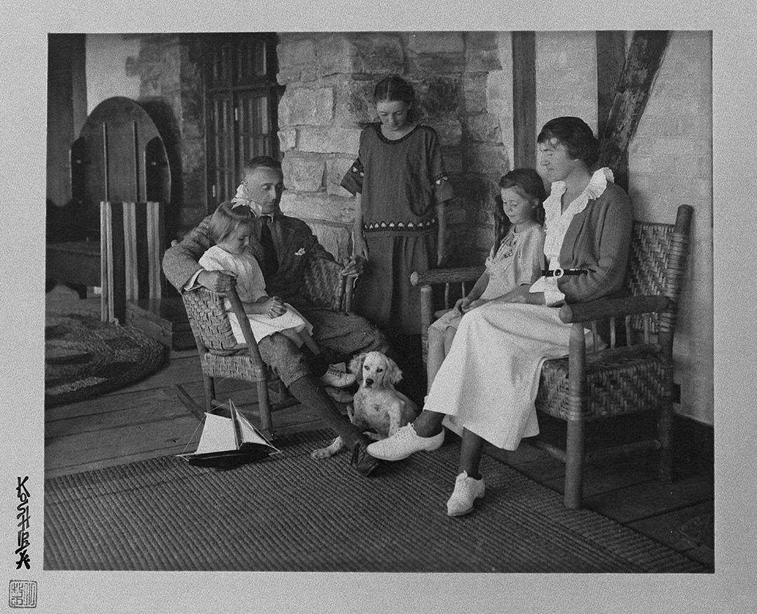 Black-and-white photograph of Mr. Myers at home with his wife, three daughters, and dog
