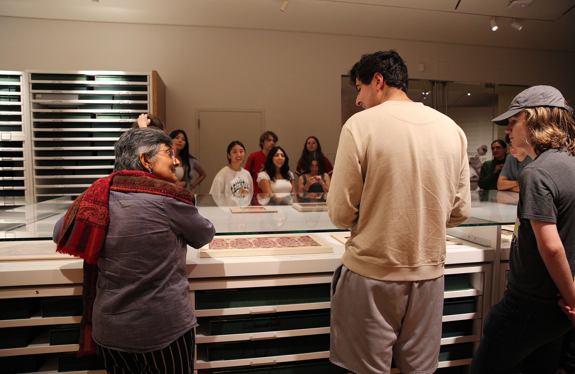 a group of students look at objects in the Cotsen Textile Traces Study Center