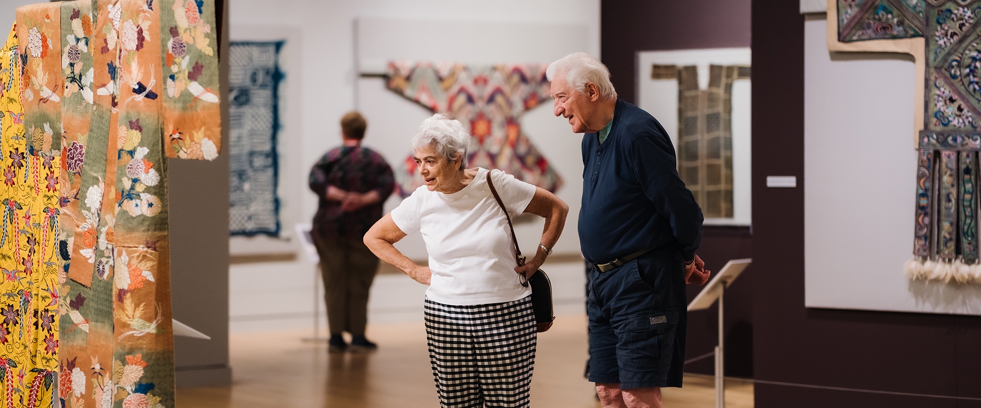 a couple looks at kimonos on display