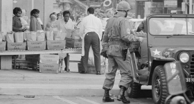 Black-and-white photograph of a street scene with soldiers