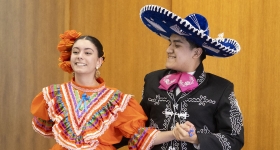 a man and a woman dressed in traditional Mexican attire dance together