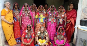 a group photo of women wearing colorful sari's and headscarves 