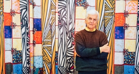 man standing in front of a colorful banner