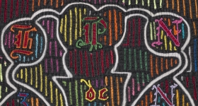 black textile with neon colored embroidered designs 
