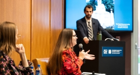 a panel speaks to a room of attendees