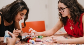 Two girls doing a yarn craft
