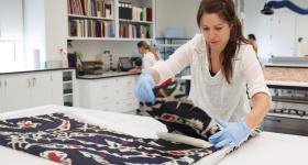 Woman unfolds textile in lab