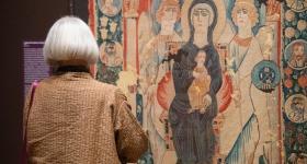 Woman looks at tapestry